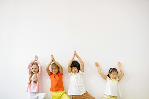 A happy child enjoying a yoga pose with vibrant energy.